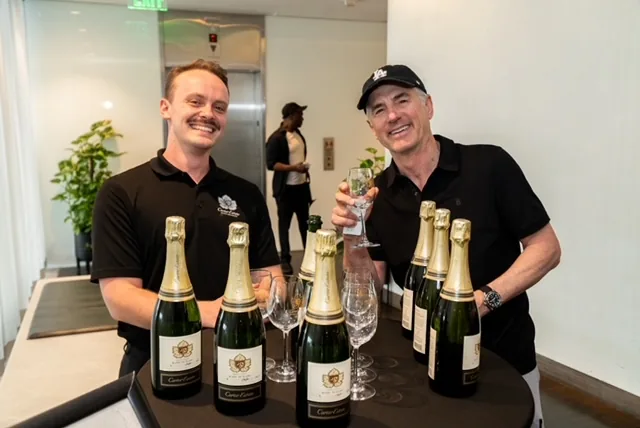 Two brand representatives presenting champagne at Jet Set Confidential