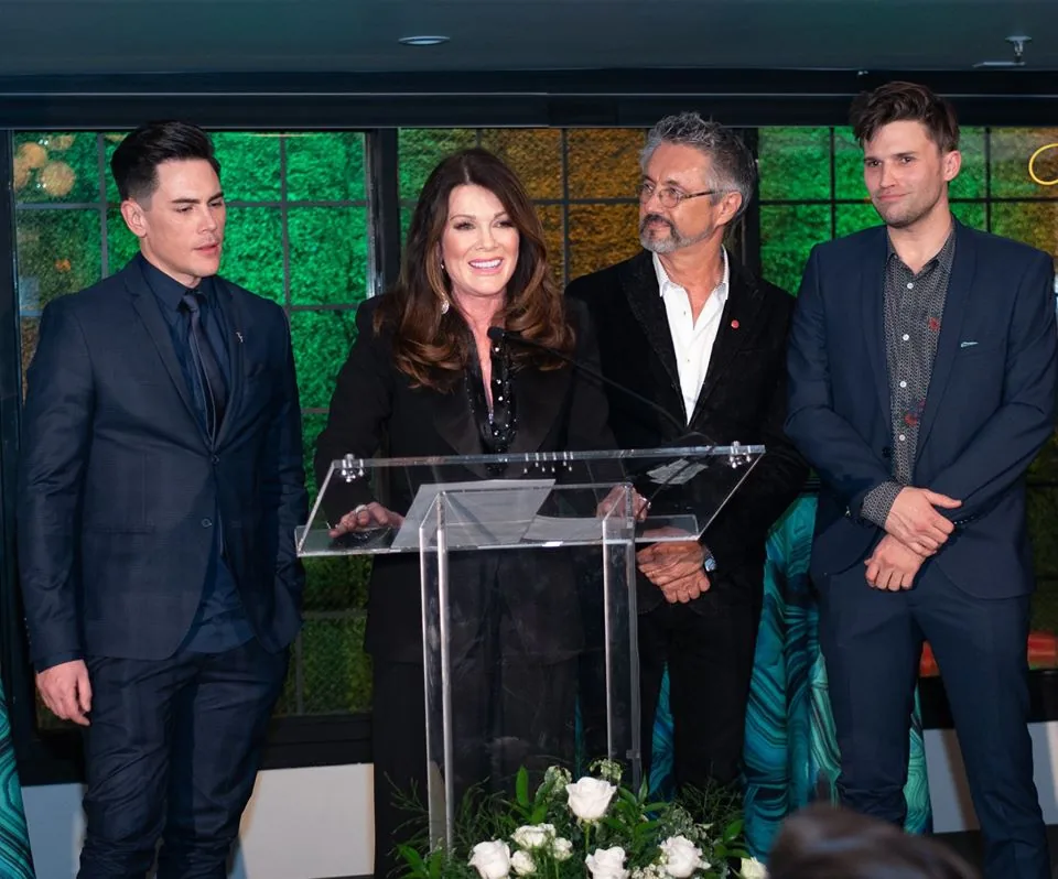 Four guests gathered around a lectern at an awards presentation